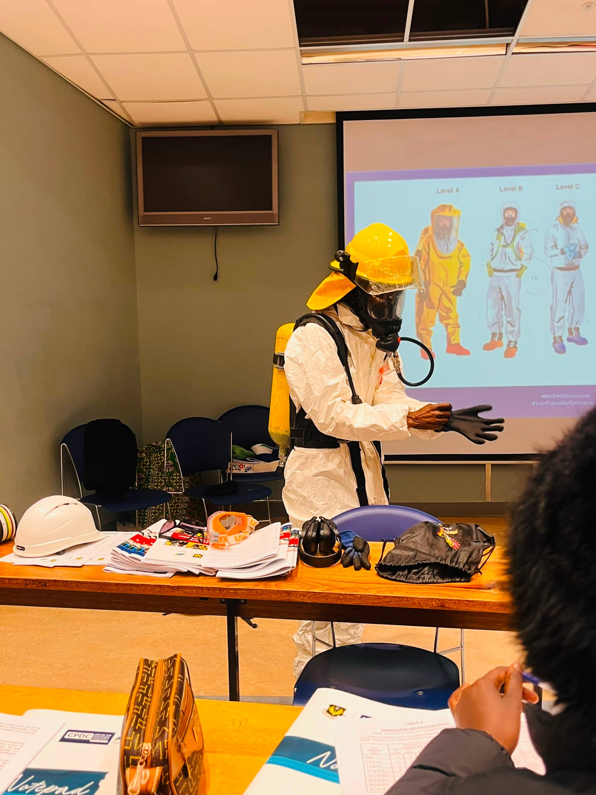 BYWC trainer demonstrating protective equipment in a classroom